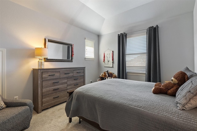 bedroom with lofted ceiling and light colored carpet