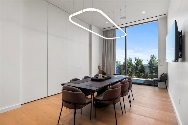 dining space with floor to ceiling windows and light wood-type flooring