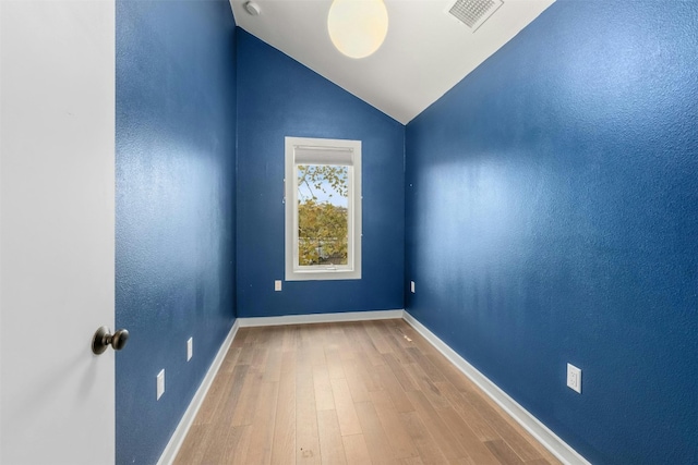 unfurnished room with lofted ceiling and wood-type flooring