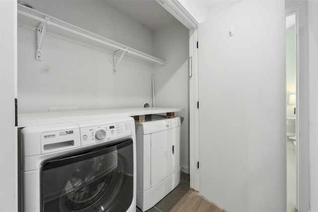 washroom with dark hardwood / wood-style flooring and washer and clothes dryer