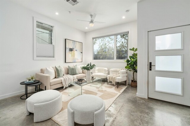 living room featuring ceiling fan and concrete flooring