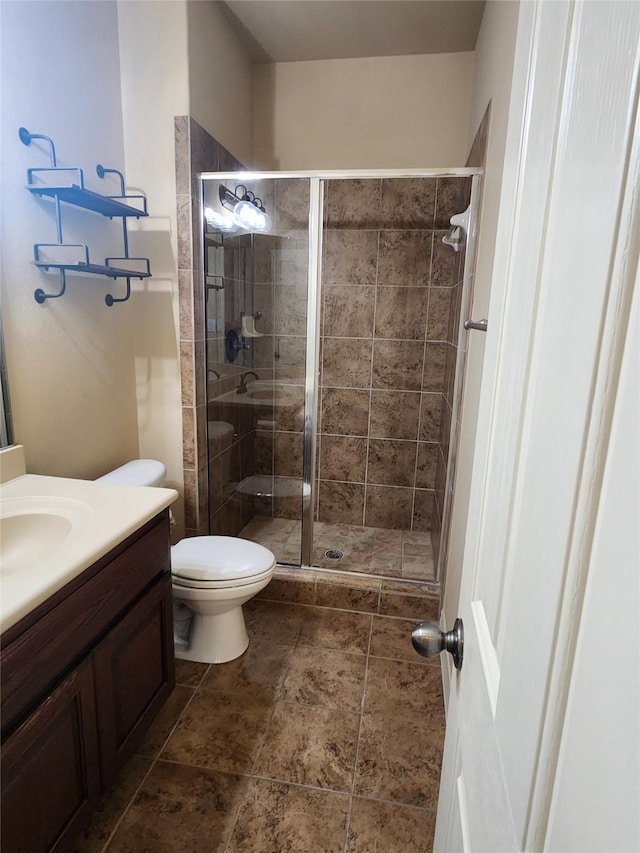 bathroom with toilet, walk in shower, and vanity