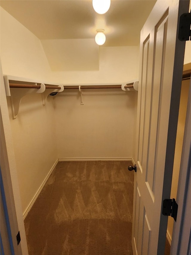 spacious closet featuring dark colored carpet