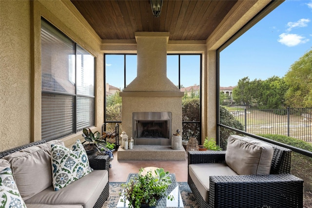 sunroom with wooden ceiling and exterior fireplace