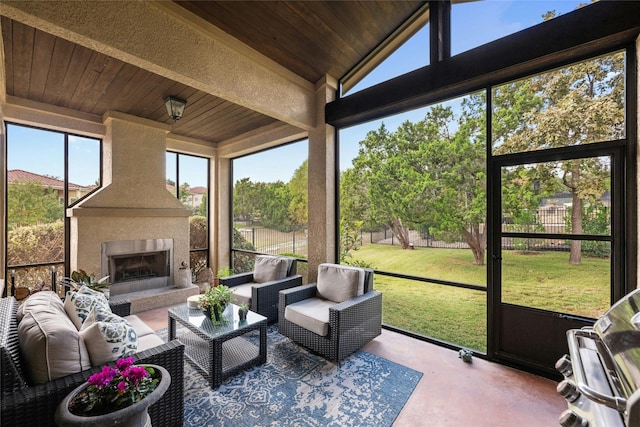 sunroom / solarium featuring a large fireplace, vaulted ceiling, and wooden ceiling