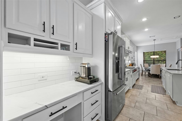 kitchen featuring decorative light fixtures, white cabinetry, sink, light stone counters, and high quality appliances