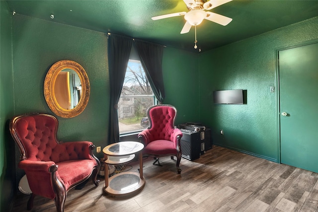 living area featuring hardwood / wood-style flooring and ceiling fan