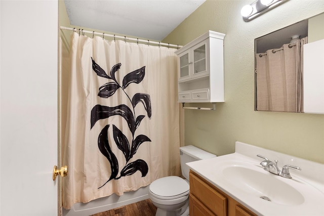 full bathroom with hardwood / wood-style floors, toilet, vanity, and shower / tub combo