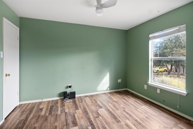 empty room featuring ceiling fan, plenty of natural light, and hardwood / wood-style floors