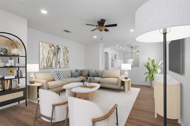 living room with a ceiling fan, wood finished floors, visible vents, recessed lighting, and arched walkways