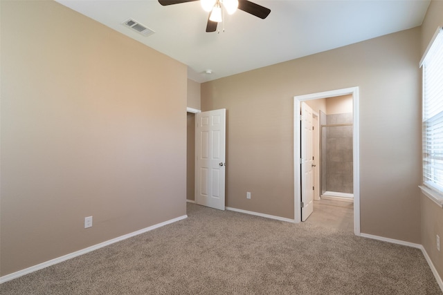 unfurnished bedroom with ceiling fan, light colored carpet, and ensuite bathroom