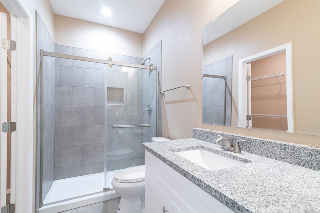 bathroom featuring vanity, toilet, and walk in shower