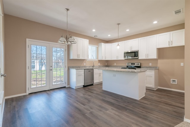 kitchen with white cabinetry, a center island, pendant lighting, and stainless steel appliances