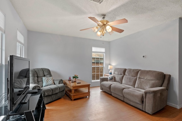 living room with wood-type flooring, a textured ceiling, and ceiling fan