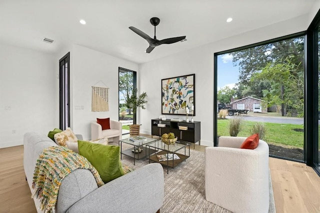 living room featuring light hardwood / wood-style floors and ceiling fan