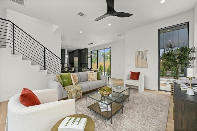 living room with ceiling fan and light hardwood / wood-style flooring