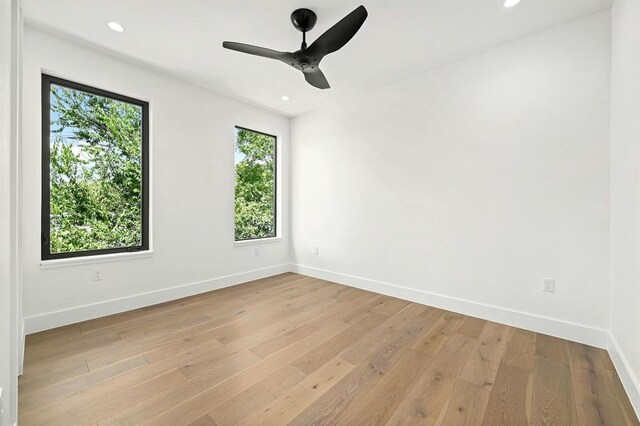 empty room with ceiling fan and light hardwood / wood-style floors