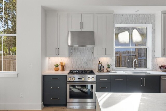 kitchen featuring light countertops, a sink, appliances with stainless steel finishes, and extractor fan