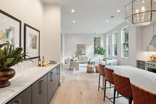 interior space with visible vents, a notable chandelier, recessed lighting, and wood-type flooring