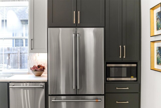 kitchen featuring plenty of natural light, light countertops, backsplash, and stainless steel appliances