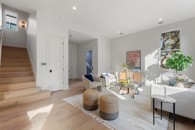 living area featuring light wood-style flooring, recessed lighting, stairs, and visible vents