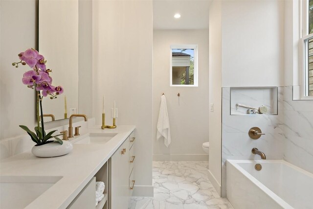 bathroom with toilet, a washtub, a sink, marble finish floor, and double vanity