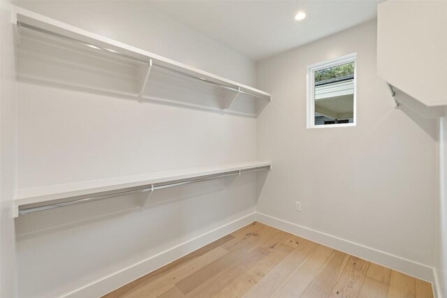 walk in closet with wood finished floors