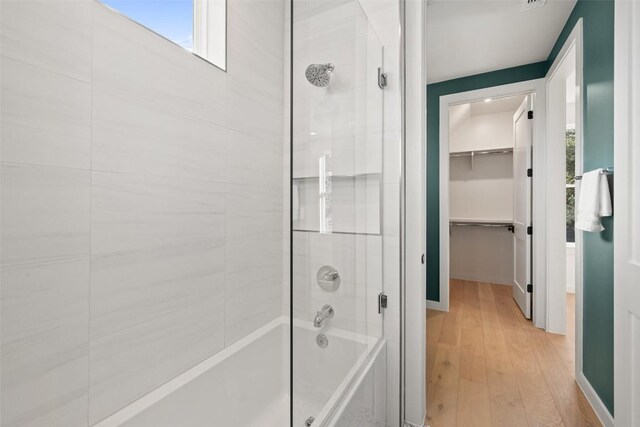 full bath with baseboards, wood finished floors, and shower / washtub combination
