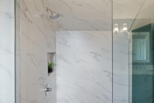 full bath featuring a sink and a marble finish shower