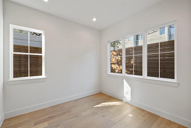 unfurnished room with light wood-style floors, baseboards, and recessed lighting