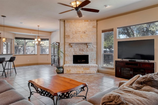 living room featuring crown molding, light tile patterned flooring, ceiling fan with notable chandelier, and a fireplace