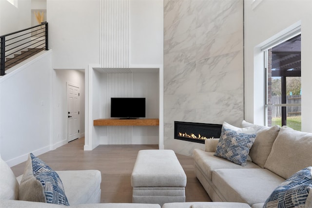 living room with hardwood / wood-style flooring, a tiled fireplace, and tile walls