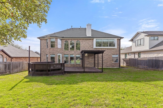 rear view of house featuring a pergola, a lawn, and a hot tub