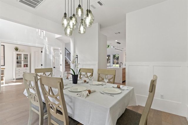 dining room featuring a chandelier, sink, and light wood-type flooring