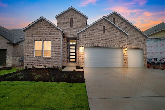 17604 Arend Path, Pflugerville, TX 78660 - view of front of home with brick siding, an attached garage, concrete driveway, and a lawn