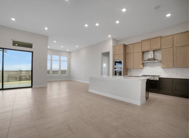 17604 Arend Path, Pflugerville, TX 78660 - kitchen featuring wall chimney range hood, appliances with stainless steel finishes, backsplash, an island with sink, and light countertops