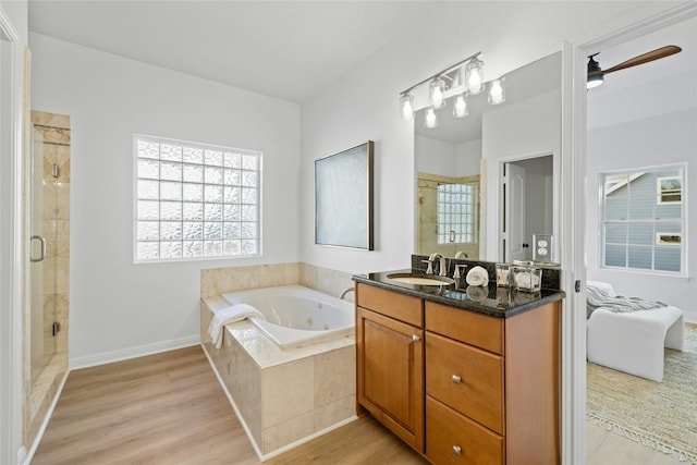 bathroom with ceiling fan, hardwood / wood-style floors, vanity, and separate shower and tub