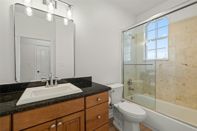 full bathroom featuring vanity, toilet, and combined bath / shower with glass door