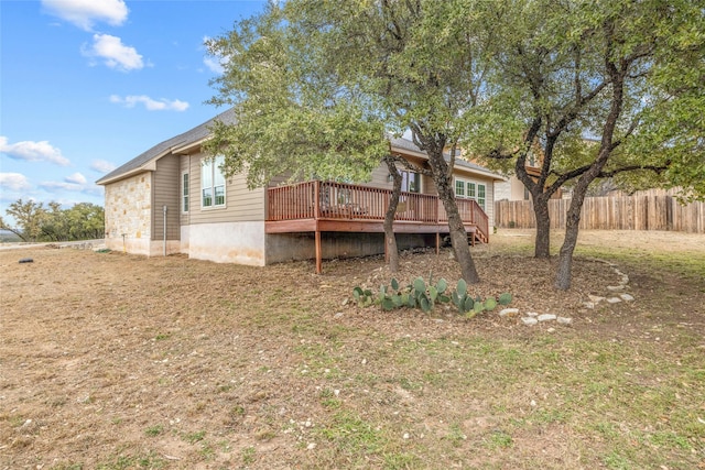 back of house with a lawn and a deck