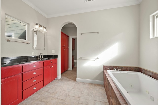 bathroom with crown molding, vanity, tiled bath, and toilet