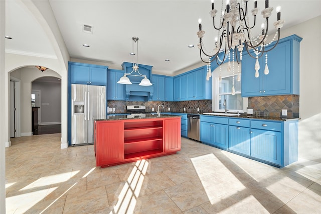 kitchen featuring stainless steel appliances, blue cabinets, sink, and a kitchen island