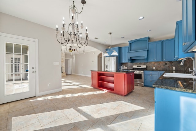 kitchen with a kitchen island, appliances with stainless steel finishes, decorative light fixtures, tasteful backsplash, and sink