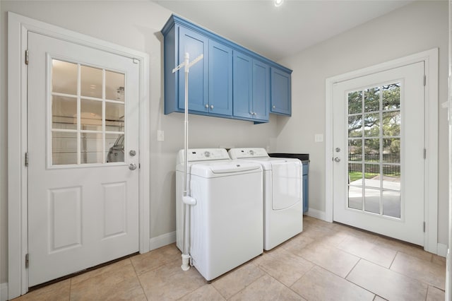 laundry room featuring cabinets, light tile patterned floors, and washer and clothes dryer