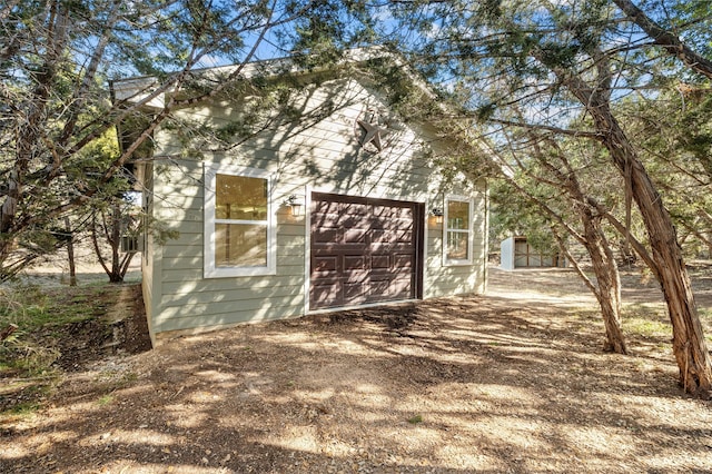 view of property exterior with a garage and an outdoor structure