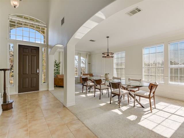 carpeted foyer entrance with crown molding and a towering ceiling