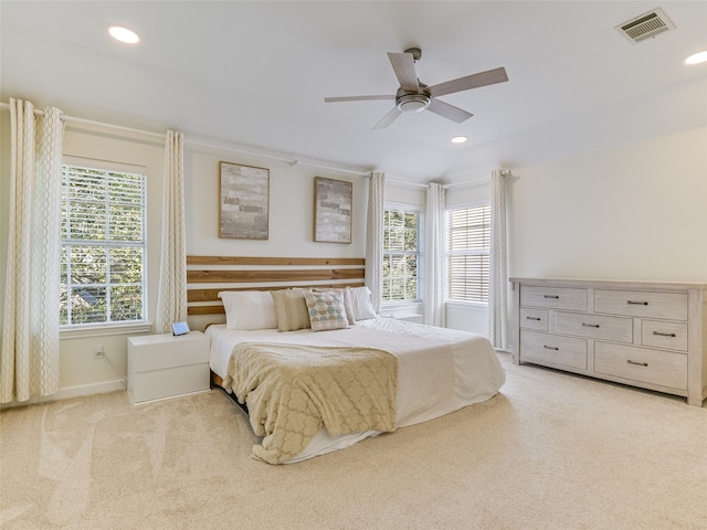 bedroom featuring multiple windows, light carpet, and ceiling fan