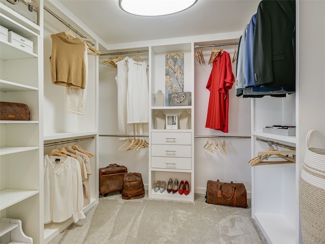 walk in closet featuring light colored carpet