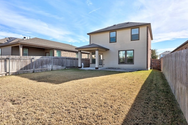 back of house with a lawn and a patio