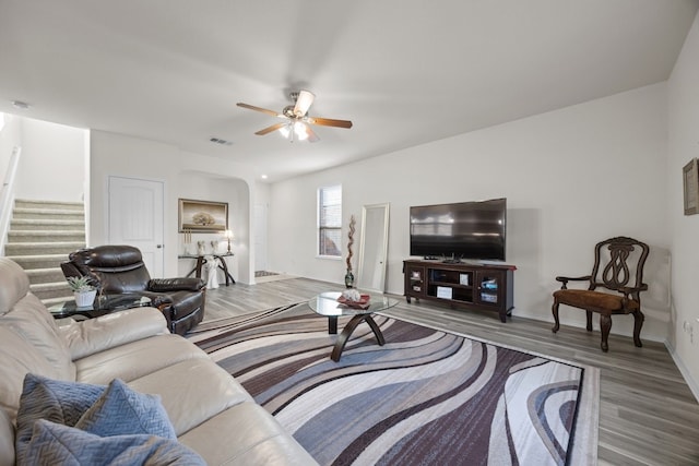 17106 Gibbons Path, Round Rock, TX 78664 - living area featuring wood finished floors, a ceiling fan, stairs, baseboards, and arched walkways