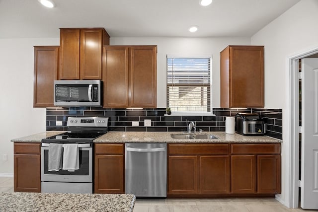 17106 Gibbons Path, Round Rock, TX 78664 - kitchen with appliances with stainless steel finishes, a sink, decorative backsplash, light stone countertops, and recessed lighting